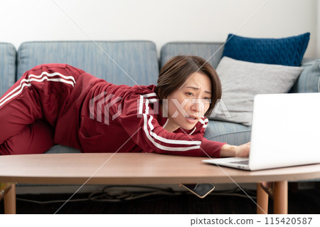 Woman watching smartphone on sofa Woman watching smartphone on sofa 115420587