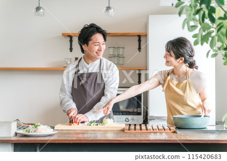 Men and women cooking in the kitchen, married couples, couples, lovers (newlyweds, cohabiting) 115420683