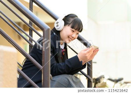 High school girl listening to music headphones High school girl listening to music headphones 115421642