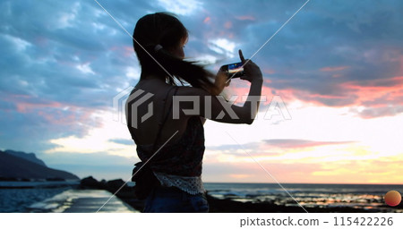 Emoji icons fly as a woman takes a beach selfie in 4k. 115422226