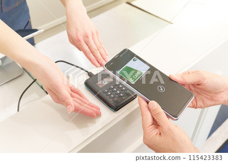 顧客和店員手邊進行無現金支付 115423383