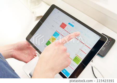 The hands of a store clerk operating a tablet cash register The hands of a store clerk operating a tablet cash register 115423391