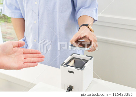 Customer and store clerk making a cashless payment 115423395