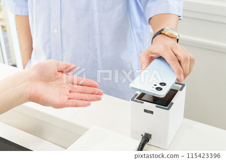 Customer and store clerk making a cashless payment 115423396