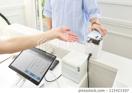 Customer and store clerk making a cashless payment Customer and store clerk making a cashless payment 115423397