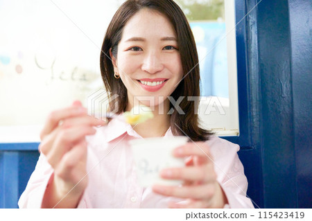 一位年輕女子微笑著提供冰淇淋 115423419