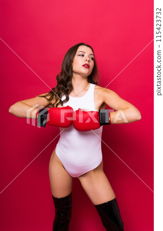 Attractive young brunette woman in boxers gloves, studio shot 115423732