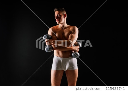 Shirtless bodybuilder holding dumbell and showing his muscular arms. Shirtless bodybuilder holding dumbell and showing his muscular arms. 115423741