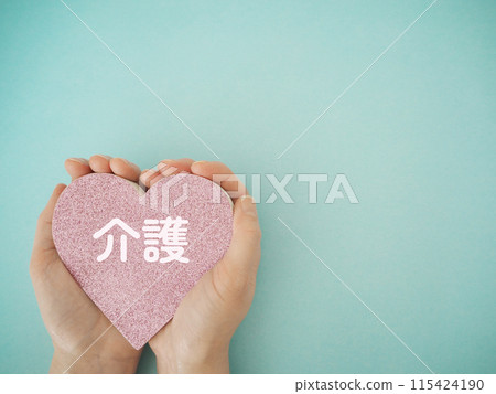 Heart held in hand with the word "care" written on it Copy space 115424190