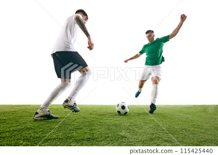 Player in white executes defensive move, challenging player in green's advance during soccer game on green lash playground against white background. Player in white executes defensive move, challenging player in green's advance during soccer game on green lash playground against white background. 115425440
