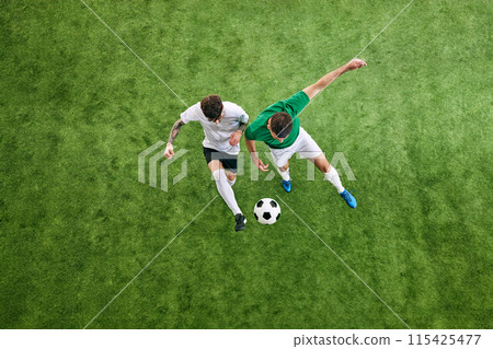 Aerial view. Two male soccer players compete for possession of ball on green lush playground. 115425477