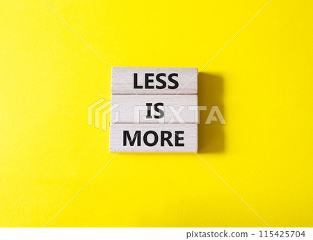 Less is More symbol. Concept words Less is More on wooden blocks. Beautiful yellow background. Business and Less is More concept. Copy space. 115425704
