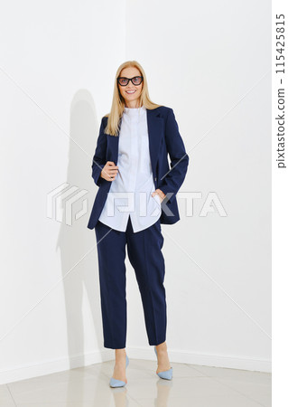 Fashion model demonstrates a classic fitted suit for everyday work in the office 115425815