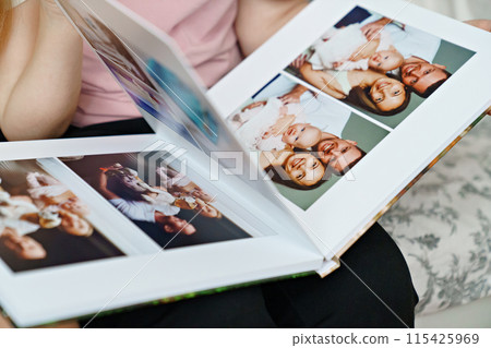 hands flip through the pages of a photo book with family photos. hands flip through the pages of a photo book with family photos. 115425969