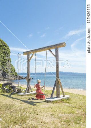 A woman riding a swing at the spectacular Maehama Beach [Minamishimabara City, Nagasaki Prefecture] 115426553