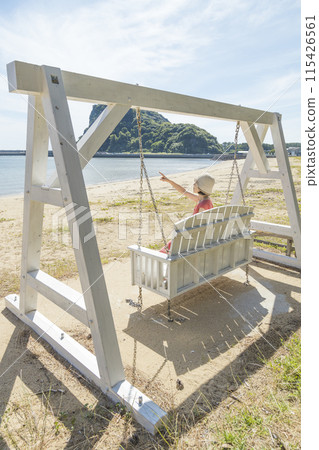 A woman riding a swing at the spectacular Maehama Beach [Minamishimabara City, Nagasaki Prefecture] 115426561