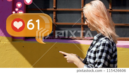 Side view of a Caucasian woman walking on the sidewalk while typing on her phone 115426606