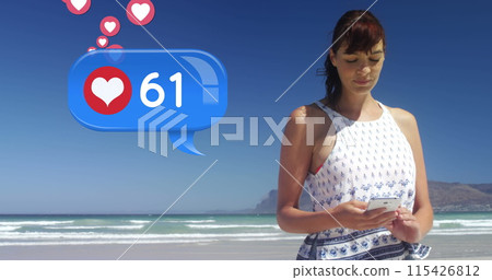 Close up of a Caucasian woman texting on the beach on a sunny day 115426812