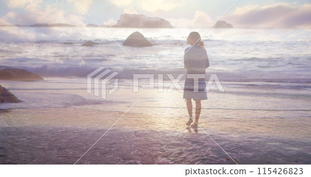 Rear view of a woman walking on the beach barefoot on a sunset Rear view of a woman walking on the beach barefoot on a sunset 115426823