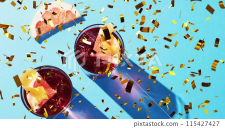 Image of confetti falling and cocktails on blue background Image of confetti falling and cocktails on blue background 115427427