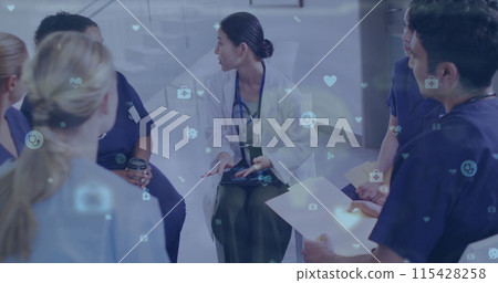 Image of medical icons over asian female doctor talking with diverse colleagues in hospital 115428258