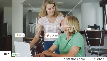 Image of social media icons over happy couple embracing at home 115428654