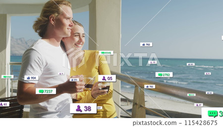 Multiple digital icons with increasing numbers over caucasian couple drinking coffee in the balcony 115428675