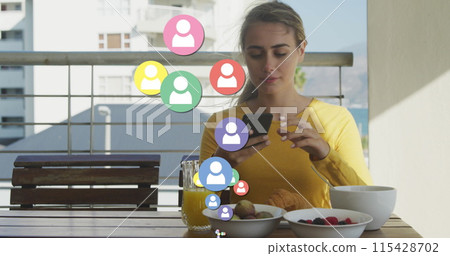 Image of social media icons over caucasian woman taking photos of breakfast with smartphone 115428702