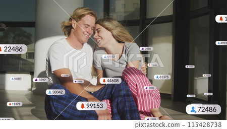 Image of social media notifications over smiling couple relaxing indoors in the sun Image of social media notifications over smiling couple relaxing indoors in the sun 115428738