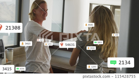Image of social media notifications over happy couple dancing in sunny kitchen 115428755