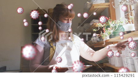 Image of virus cells over caucasian woman with face mask inspecting plants 115429291