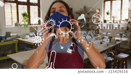 Image of virus icons over caucasian woman with face mask in workshop Image of virus icons over caucasian woman with face mask in workshop 115429316