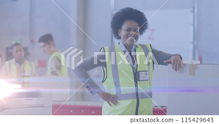 Image of glowing light over african american woman working in warehouse 115429643