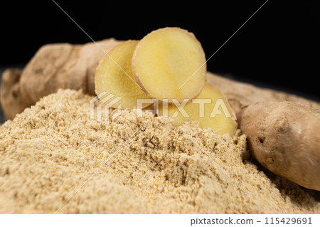 Ground ginger as a fine dry powder, macro on a black background 115429691