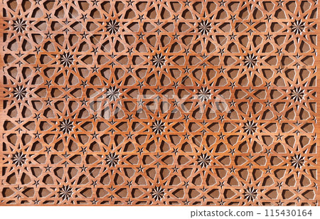 Detail of wooden door with traditional islamic ornament. Wood window shutter with antique iranian geometric pattern. Oriental ornament with artistic carving for wood 115430164