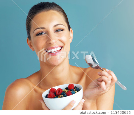 Woman, portrait and happy with cereal in studio for healthy meal, nutrition diet and digestion benefits. Smile, breakfast and female fitness model, isolated on blue background and eating food in bowl Woman, portrait and happy with cereal in studio for healthy meal, nutrition diet and digestion benefits. Smile, breakfast and female fitness model, isolated on blue background and eating food in bowl 115430635