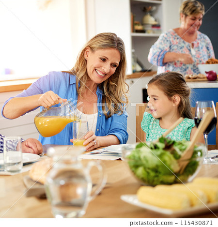 Food, orange juice or mother and daughter in house with love, meal and dining table bonding. Brunch, diet and girl with mom at home for fruit drink, eating or organic nutrition with green raw salad 115430871