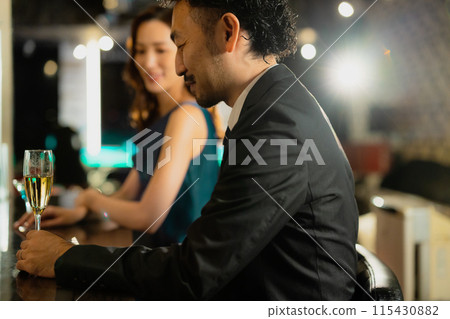 Men and women drinking at a bar 115430882