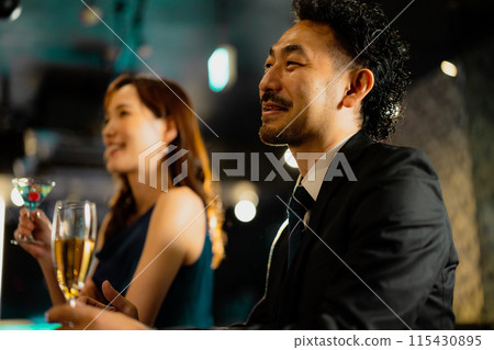 Men and women drinking at a bar Men and women drinking at a bar 115430895
