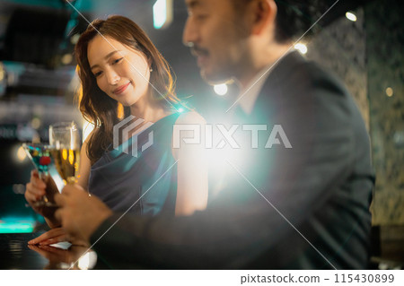 Men and women drinking at a bar 115430899