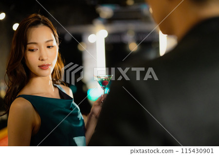 Men and women drinking at a bar 115430901