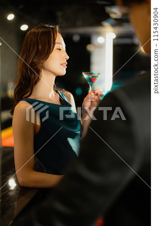 Men and women drinking at a bar 115430904