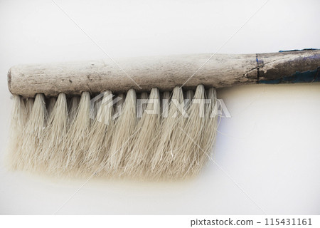 An old brush with a wooden handle on a white background. An old detail. An old brush with a wooden handle on a white background. An old detail. 115431161