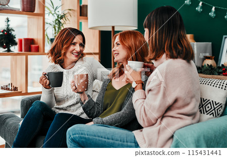 Christmas, group and friends with coffee, gossip or happy in vacation of festive season or laughing. Home, lounge or people with hot chocolate, warm or smile of girls, together and excited for winter 115431441