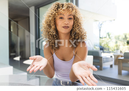 Young biracial woman gestures during a conversation at home on a video call Young biracial woman gestures during a conversation at home on a video call 115431605