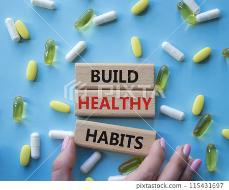 Healthy habits symbol. Concept word Build Healthy habits on wooden blocks. Doctor health. Beautiful blue background with pills. Healthy lifestyle and Healthy habits concept. Copy space 115431697