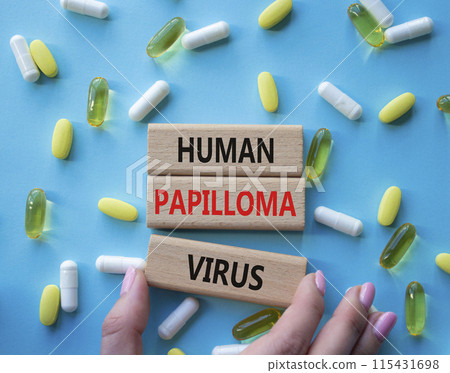 Human Papilloma Virus symbol. Concept word Human Papilloma Virus on wooden blocks. Doctor hand. Beautiful blue background with pills. Medicine and Human Papilloma Virus concept. Copy space 115431698