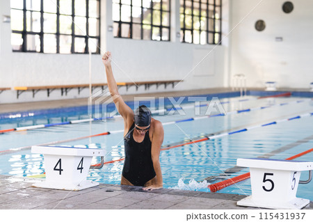 Caucasian female athlete swimmer celebrates a victory in a swimming pool 115431937