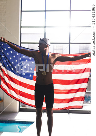Young biracial male athlete swimmer celebrates victory at a swimming pool 115431969