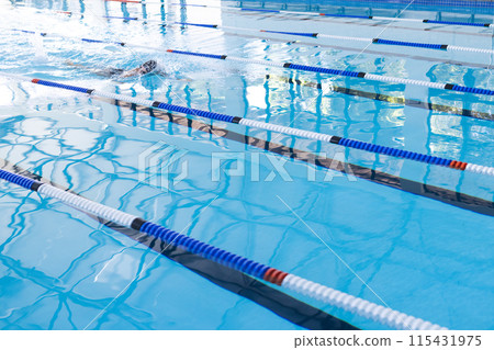 Swimmer in action at a competitive pool event, with copy space 115431975